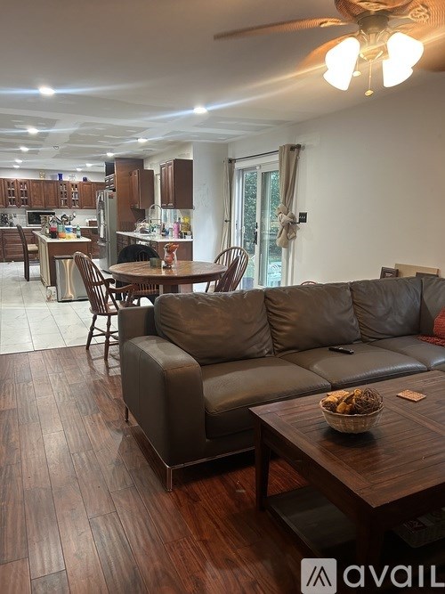 A living room with a couch, a table, and a ceiling fan.