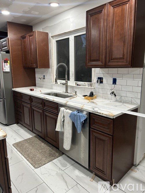 A kitchen with brown cabinets and a white counter top.