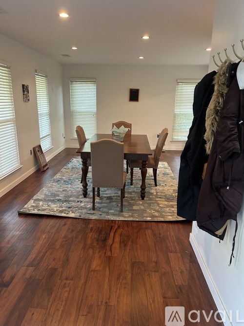A dining room with a wooden table and chairs.