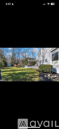 A house with a green lawn and trees in the background.
