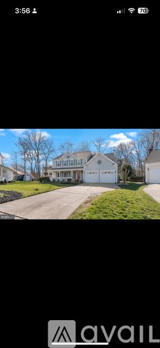 A house with a driveway and a tree in front of it.
