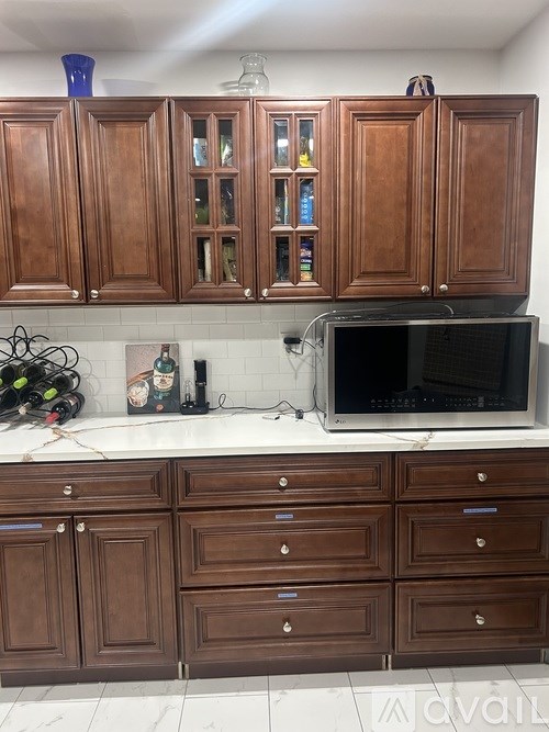 A kitchen with wooden cabinets and a microwave oven.