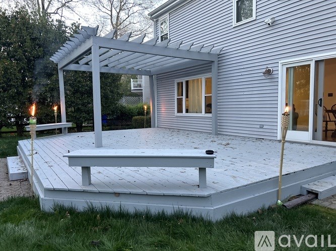 A patio with a bench and a pergola is available.