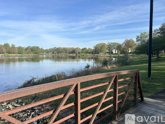 A wooden bridge over a calm lake with a clear blue sky.