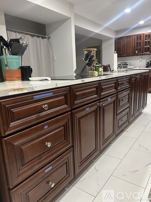 A kitchen with brown cabinets and a white counter.