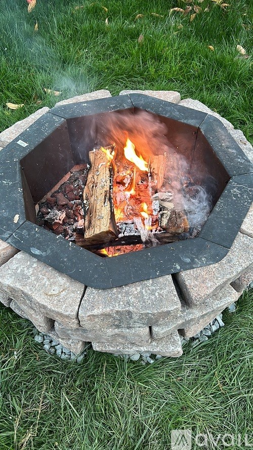 A fire burns in a stone fire pit.