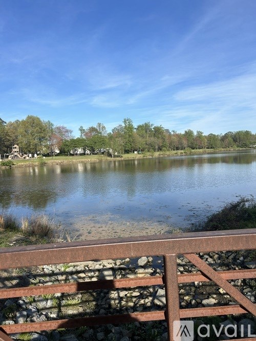 A lake with a bridge in the foreground and trees in the background.