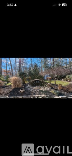 A garden with a small pond and a house in the background.