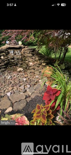 A garden with a stone wall and a water feature.
