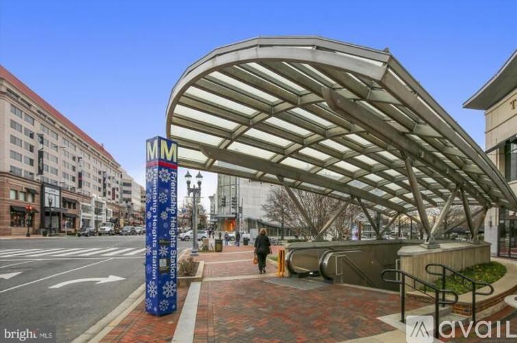 A pedestrian walkway with a blue pole and a white sign with the letters "MM" on it.