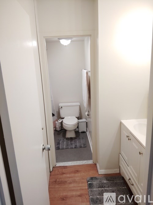 A bathroom with a toilet, sink, and mirror.
