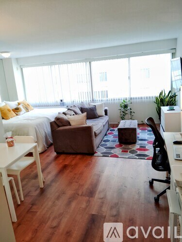 A bedroom with a bed, couch, and chair.