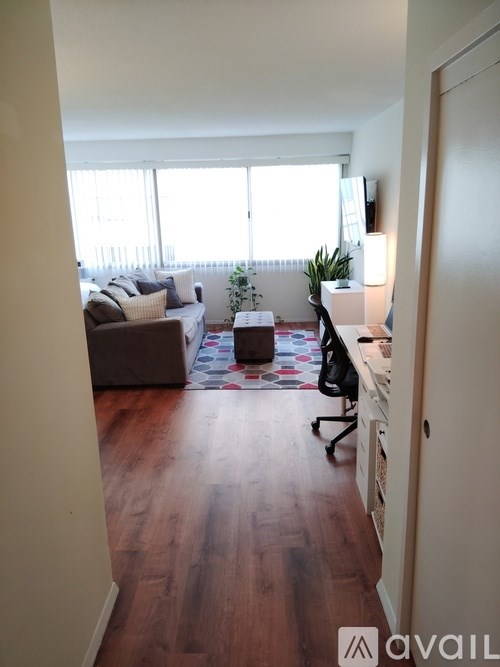 A living room with a couch, a rug, a chair, and a television.
