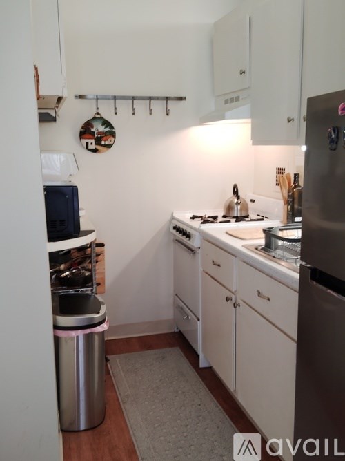 A kitchen with white cabinets and a stainless steel refrigerator.