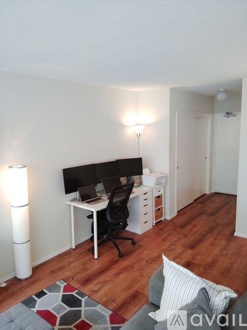 A room with a desk, chair, and a floor lamp.