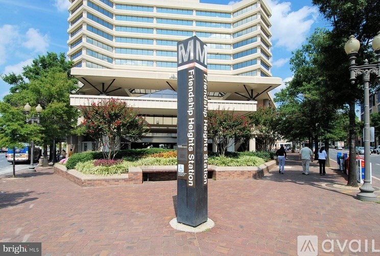 A tall black sign with white lettering stands in front of a building.