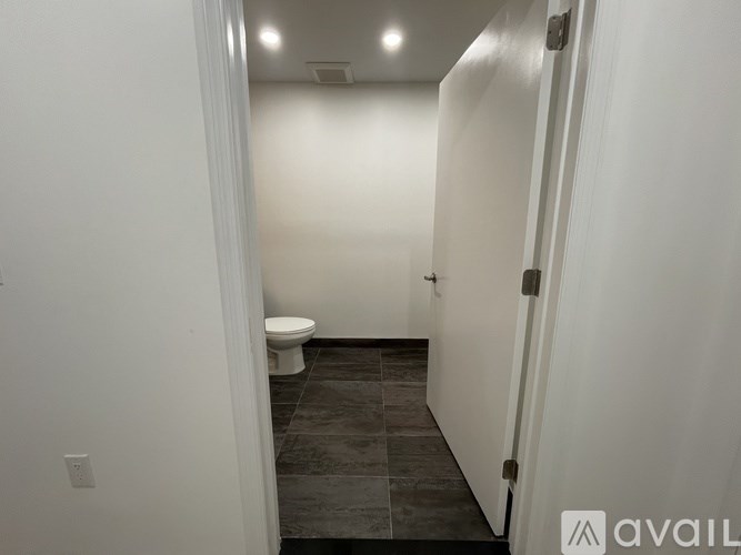 A bathroom with a toilet and tiled floor.