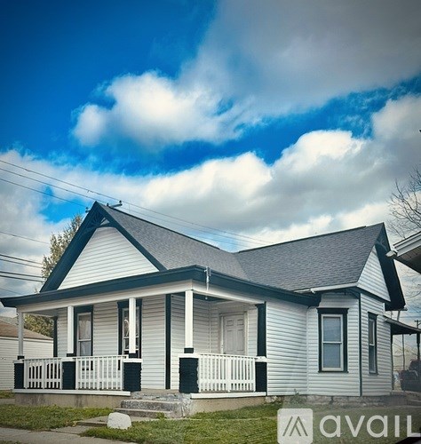 A small house with a porch and a front yard.