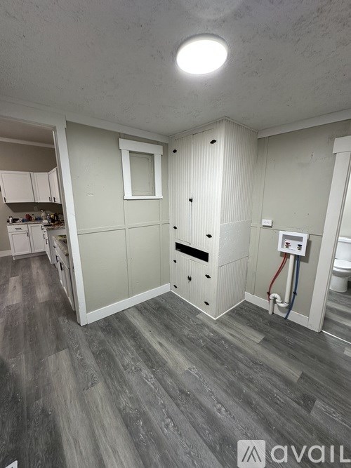 A bathroom with a toilet, sink, and a window.