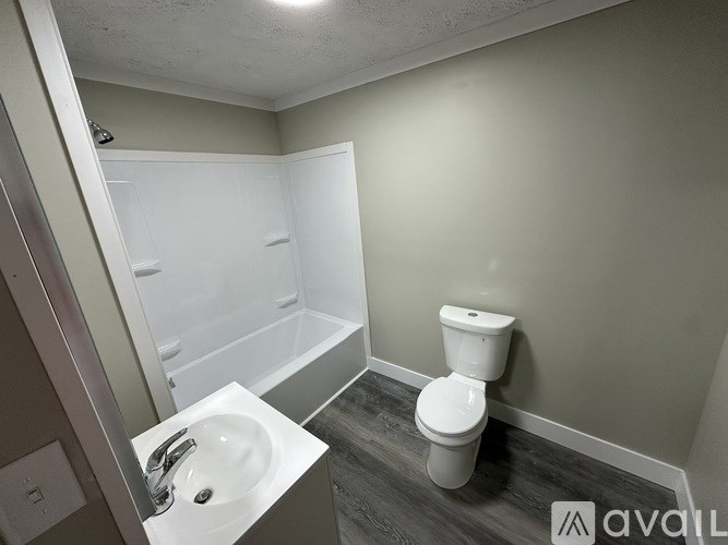 A bathroom with a toilet, sink, and bathtub.