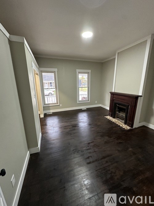 A room with a fireplace and wood flooring.