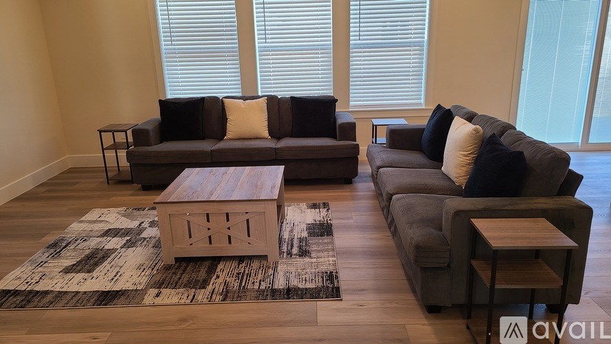 A living room with a brown couch, a wooden coffee table, and a rug.
