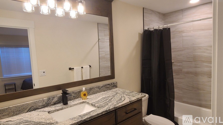 A bathroom with a marble countertop and a large mirror.
