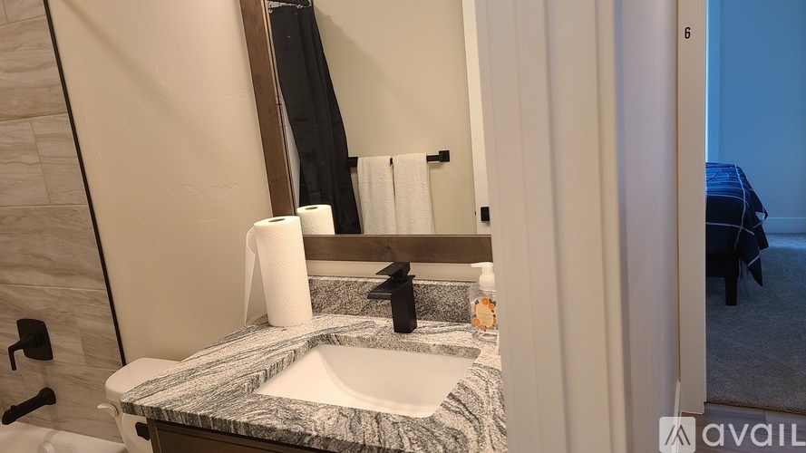 A bathroom with a marble countertop and a mirror above the sink.