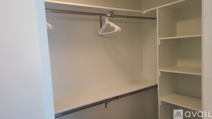 A white closet with a hanger and shelves.