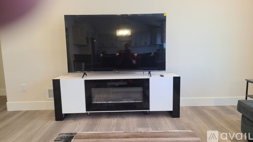 A bed with a blue and white comforter sits next to a window with blinds.