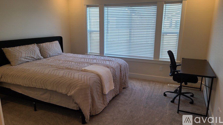 A bedroom with a bed, desk, and chair.