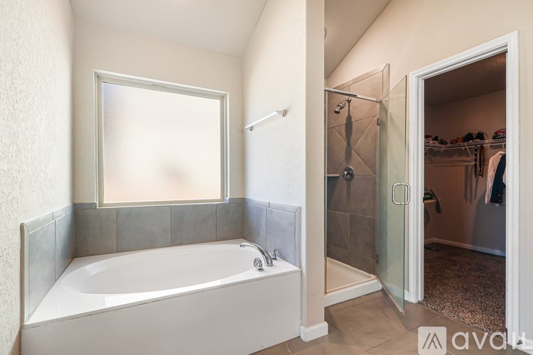 A bathroom with a white tub and a walk-in shower.
