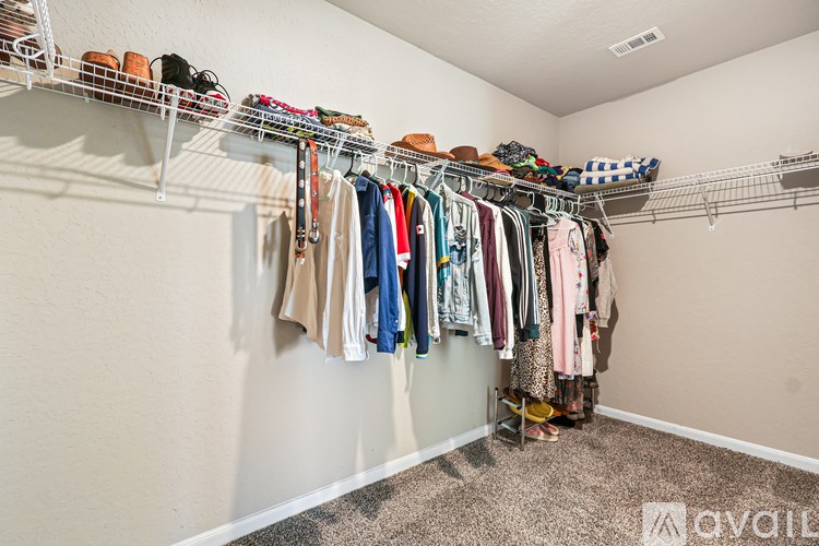 A well organized closet with clothes and shoes on shelves.