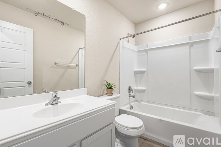 A bathroom with a white toilet, sink, and bathtub.