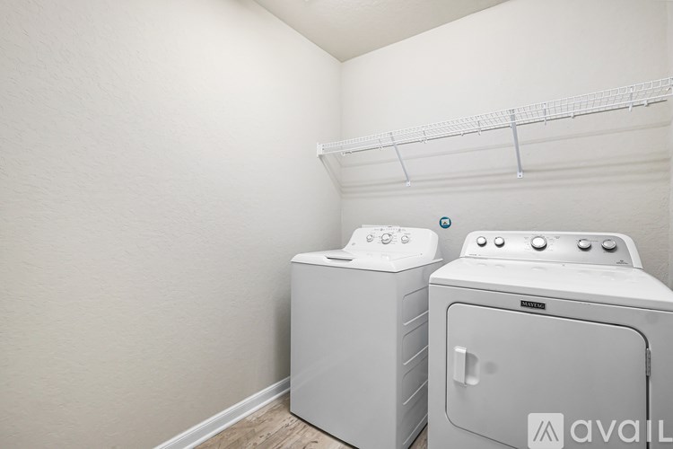 Two white front loading washing machines in a laundry room.