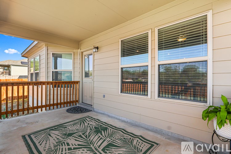 A balcony with a rug and a potted plant.