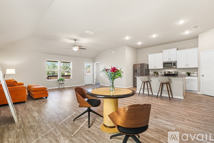 A modern living room with a dining area and kitchen in the background.
