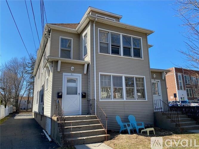 A two-story house with a white door and a small porch.