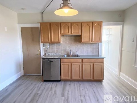 A kitchen with wooden cabinets and a tile backsplash.