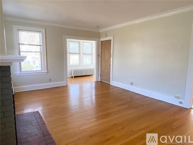 A room with wooden floors and a fireplace with a window.