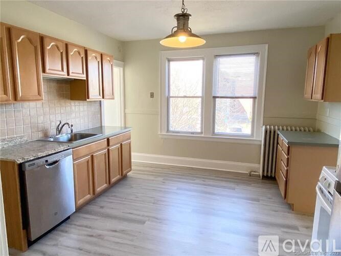 A kitchen with wooden cabinets and a stainless steel dishwasher.