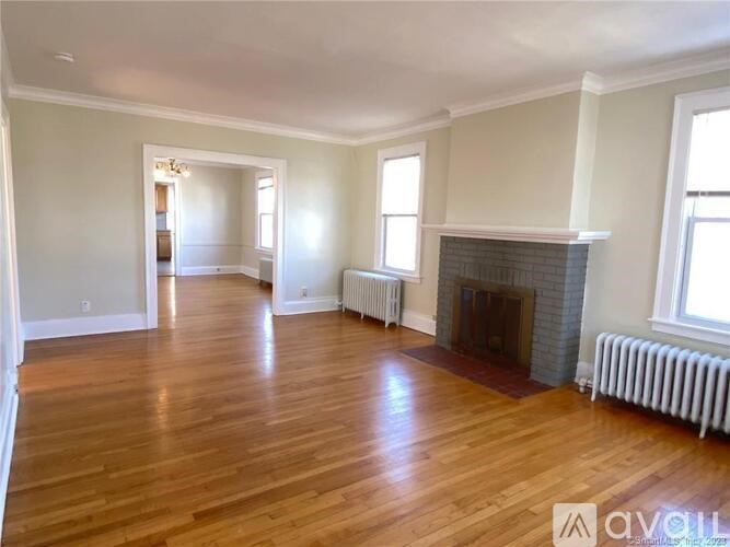 A living room with a fireplace and wood flooring.
