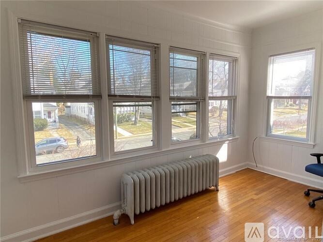 A room with a radiator and three windows.