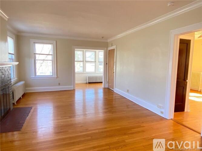 A spacious room with wooden floors and white walls.