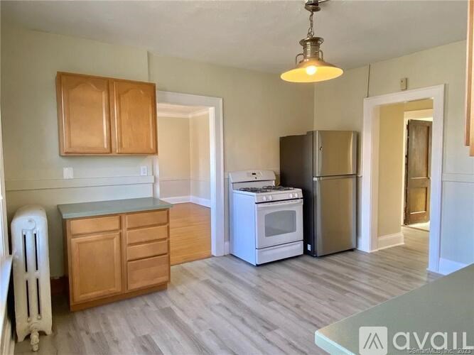 A kitchen with wooden cabinets and a white stove top oven.