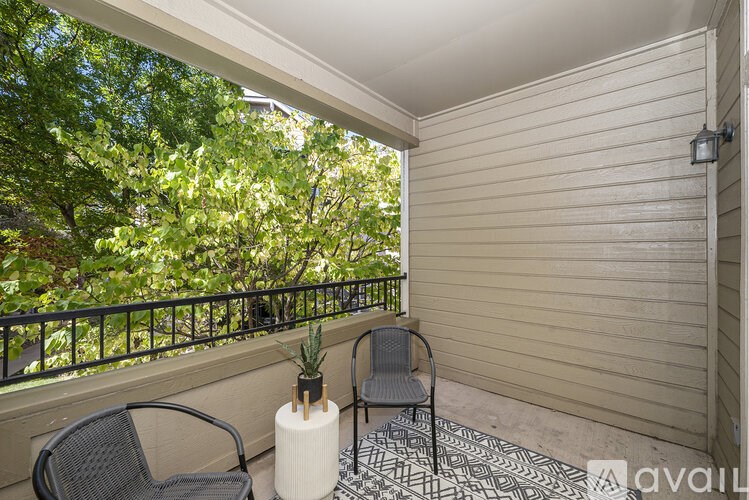 A balcony with a chair and a table with a plant on it.