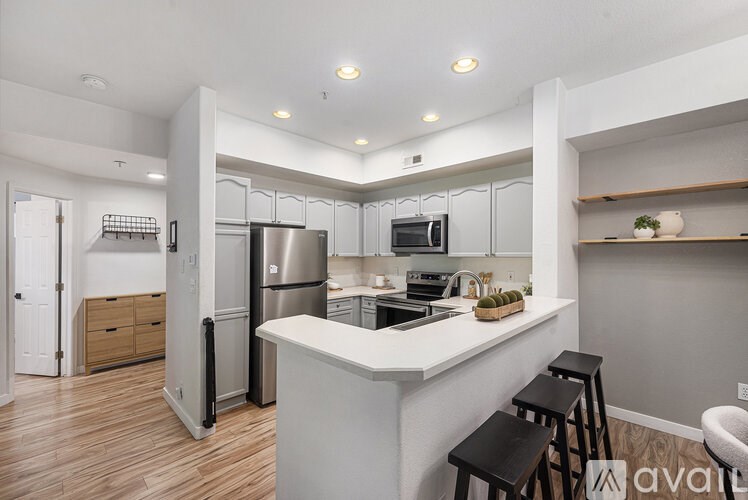 A kitchen with a white countertop and stainless steel appliances.