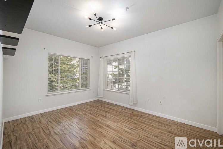A room with wooden flooring and a ceiling fan.