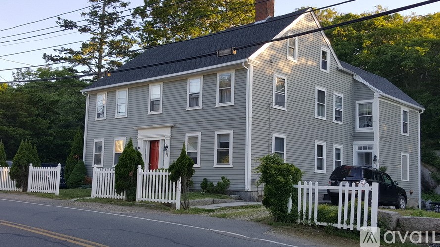 A house with a red door and white picket fence.