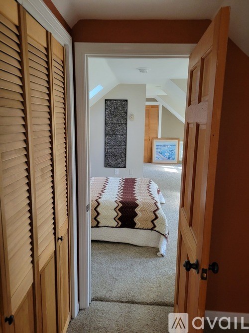 A room with a bed and a rug is visible through an open door.
